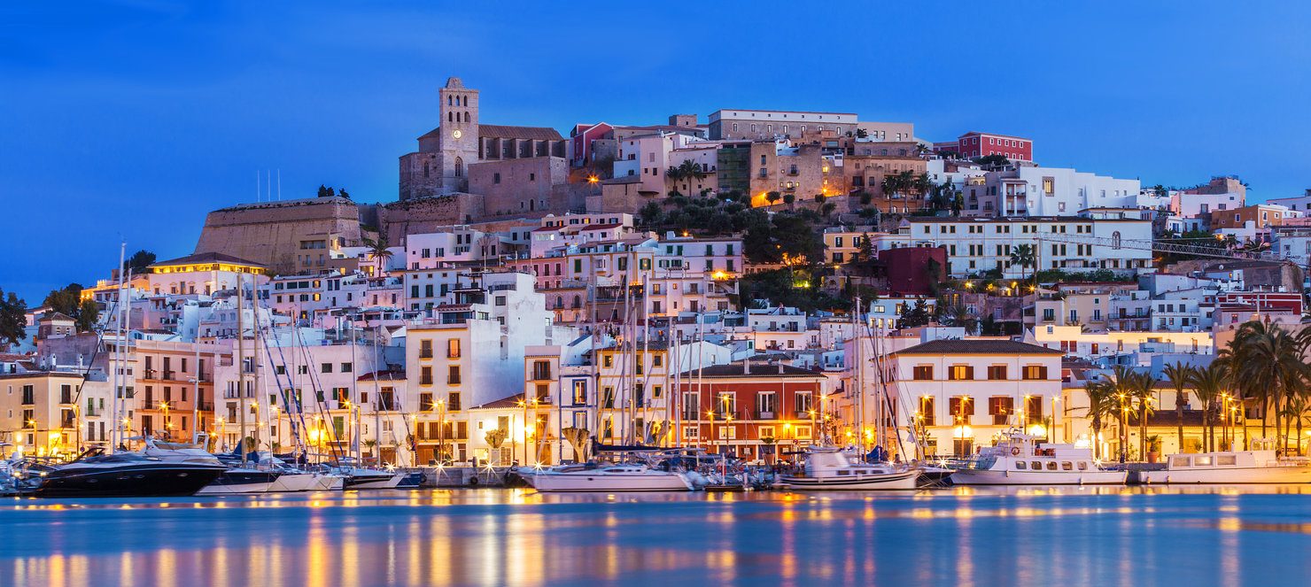Ibiza Town harbour and the old town of Dalt Vila lit up at dusk, home to Pacha where Chris Stussy's USS night lands in 2026
