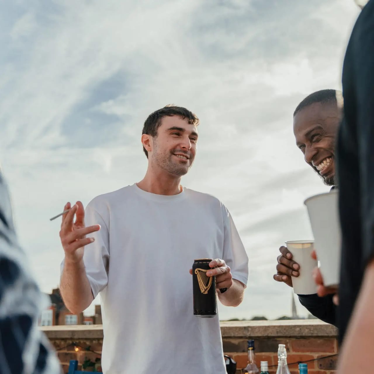 Fred again.. in a white tee on a London rooftop, in conversation over a drink