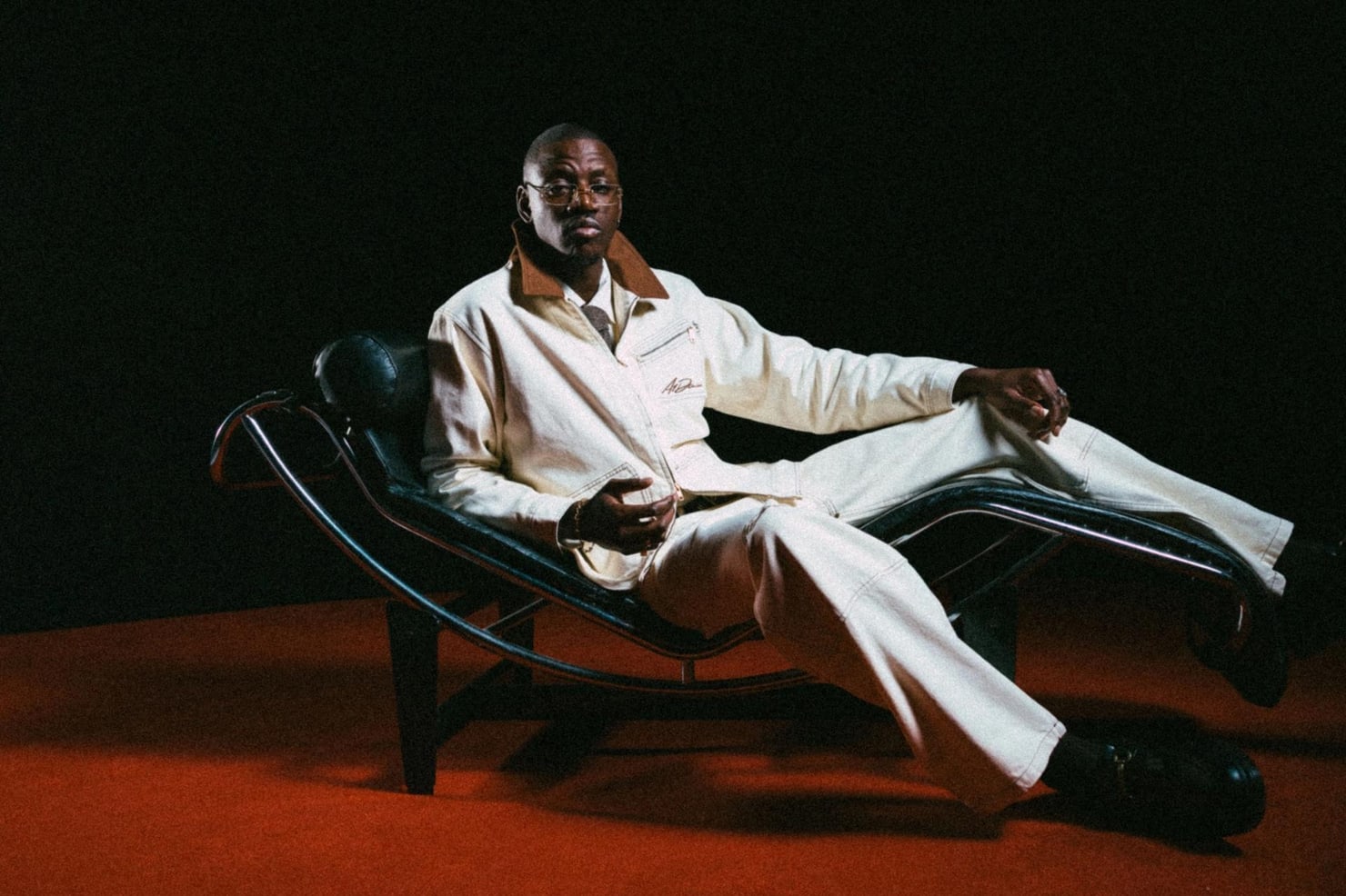 KILIMANJARO, the Zambian-heritage afro house DJ and producer, reclining in a cream suit