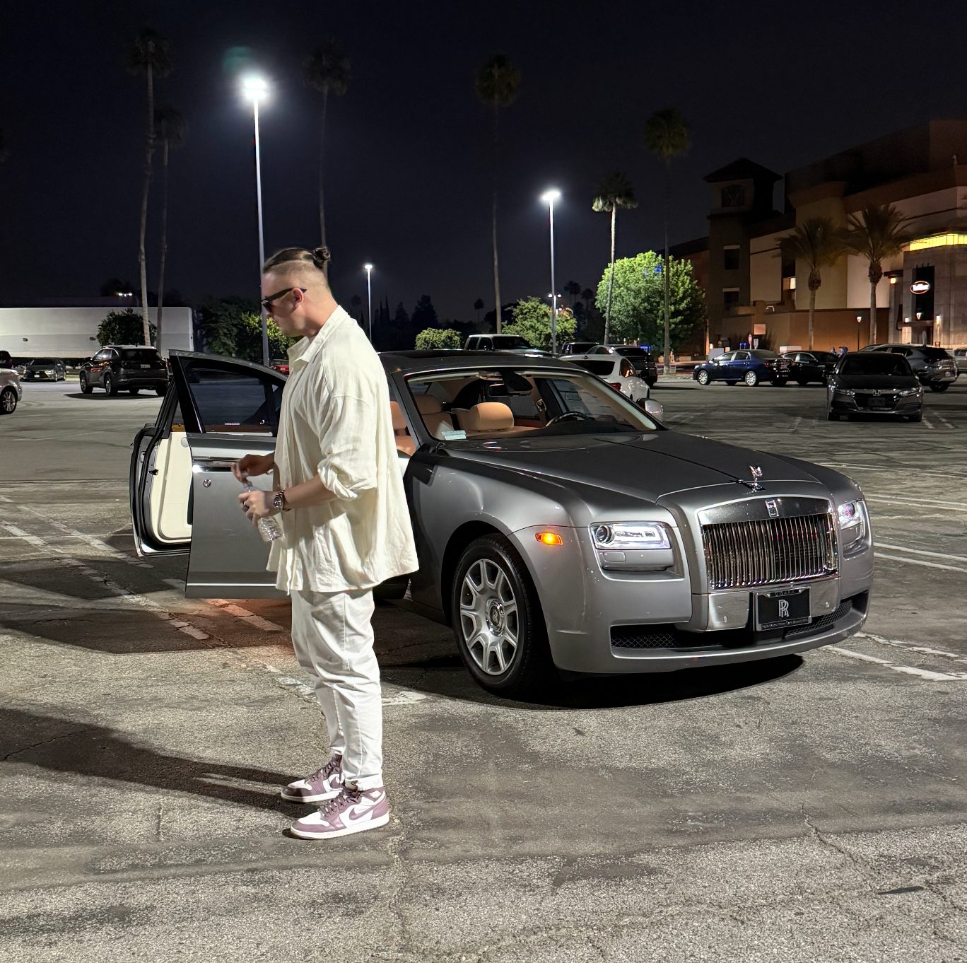 MNEEMO standing next to a Rolls Royce in Los Angeles on a parking lot late at night