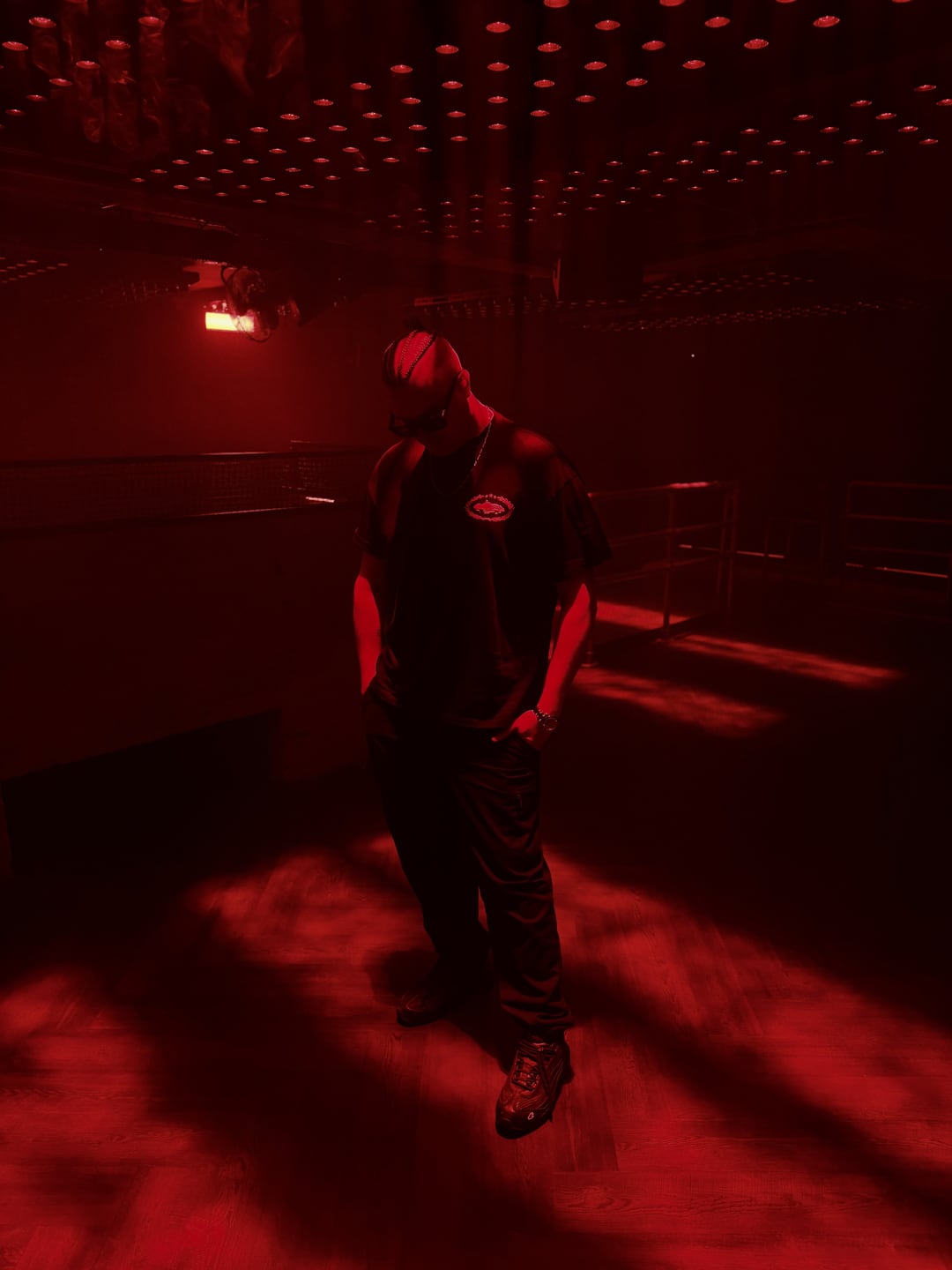 MNEEMO alone under deep red light on the Gallery dancefloor, hood up, head down, January 2026.