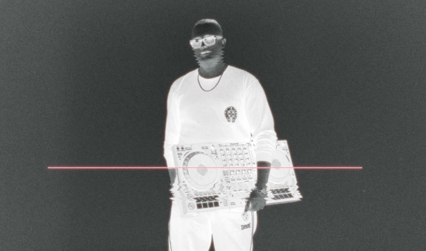 An inverted image of MNEEMO (Yaroslav Gorovoy) holding a DJ controller against a black background, with a pink horizontal line and a logo on his clothing.