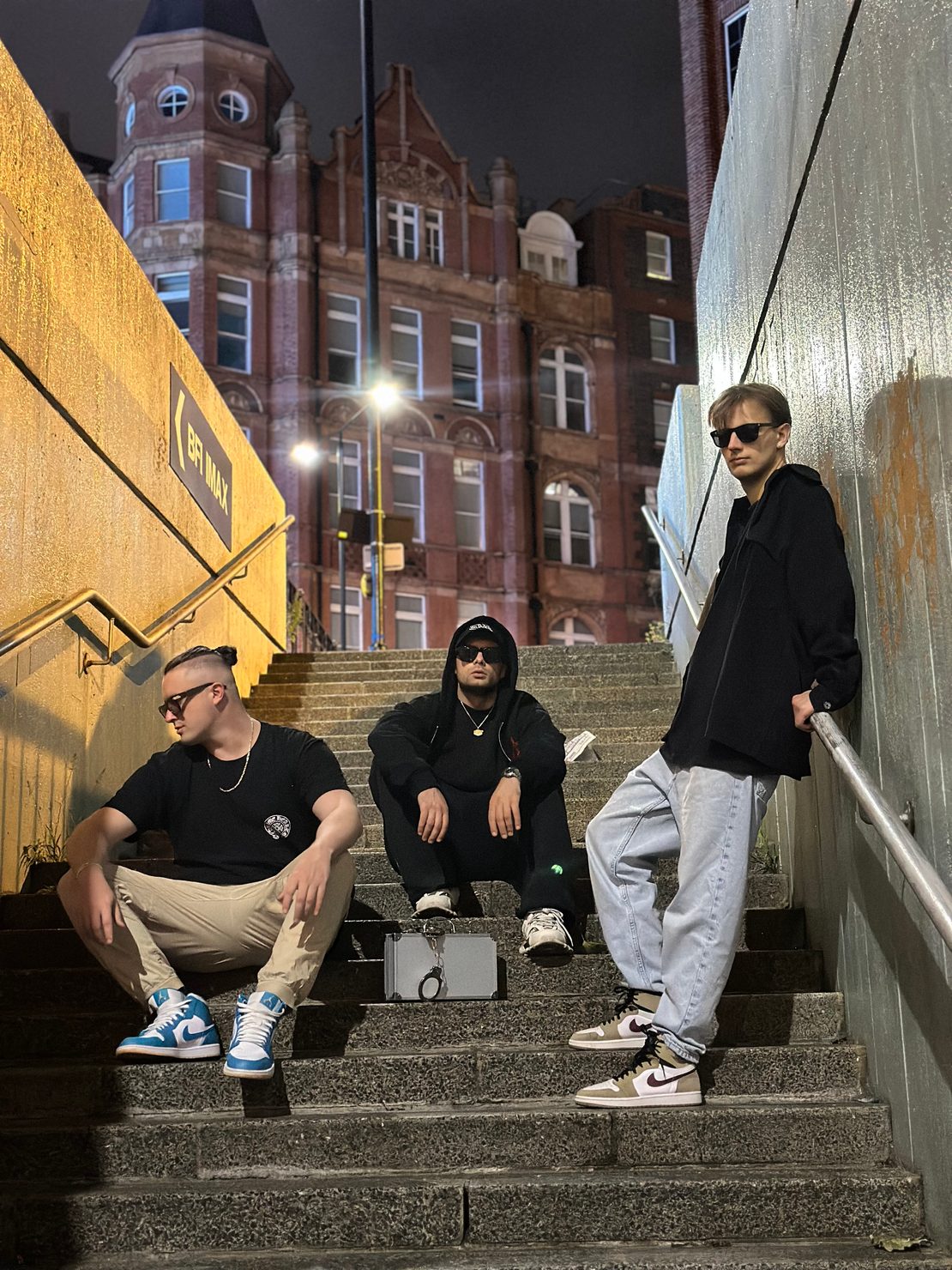 MNEEMO (Yaroslav Gorovoy), FLASH and E4TEEN posing for the promo shoot for Facile on a London staircase, with a cinematic background.