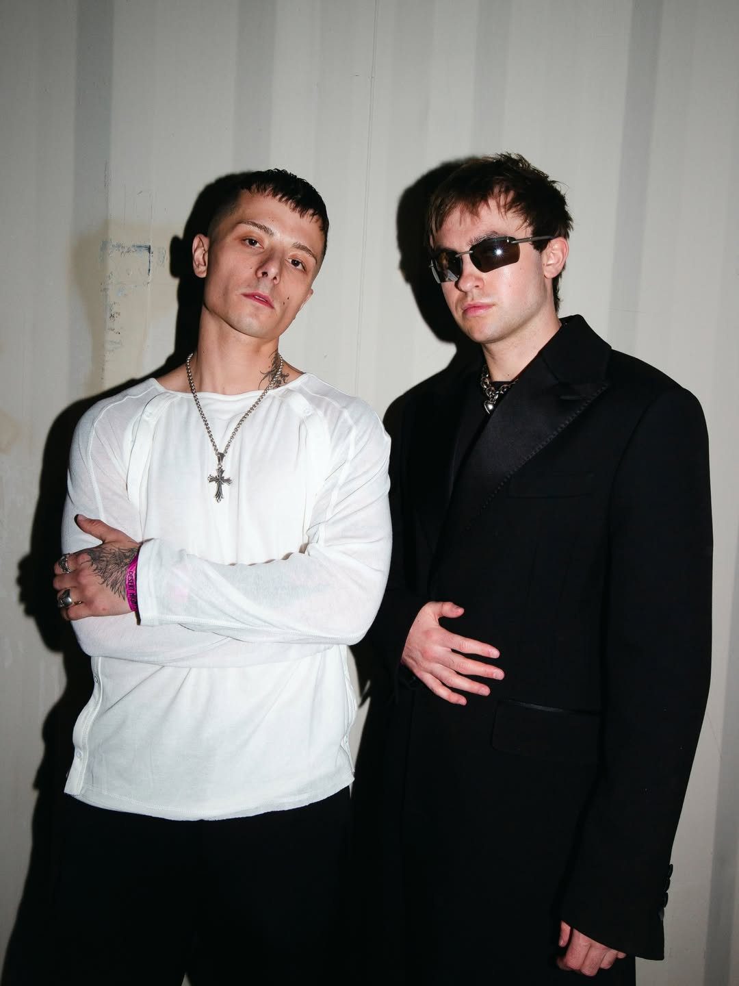 Prospa members Harvey Blumler and Guiorgi “Gosha” Smith photographed backstage in contrasting black and white outfits.