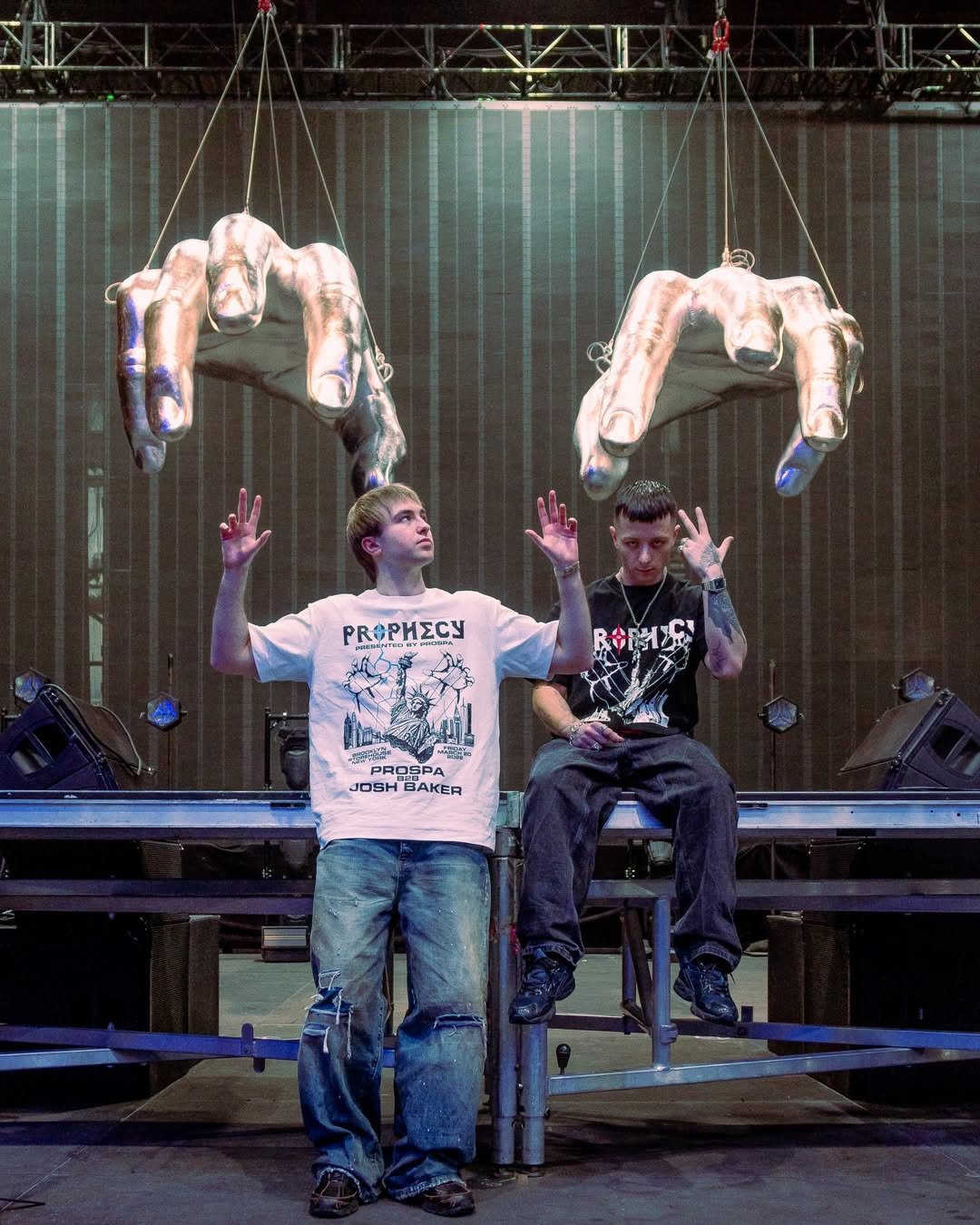 Prospa backstage on stage beneath the large suspended silver hands from their PROPHECY production.