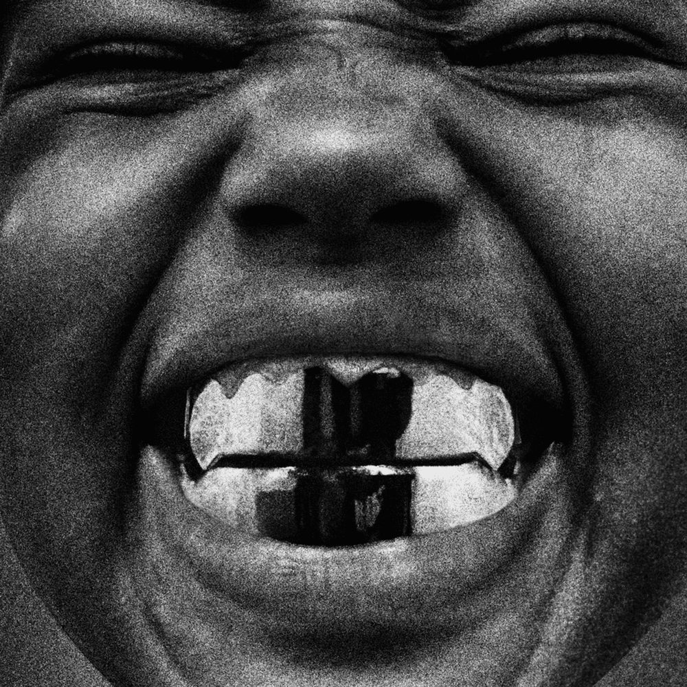 Kanye West (Ye) studio album Bully cover: a child with closed eyes smiling widely, showing metallic grills on their teeth. Black-and-white photo conveying rage and energy.